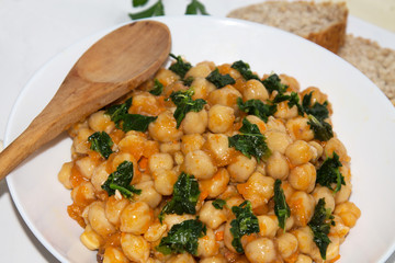 bowl of cooked chickpeas with spinach closeup view