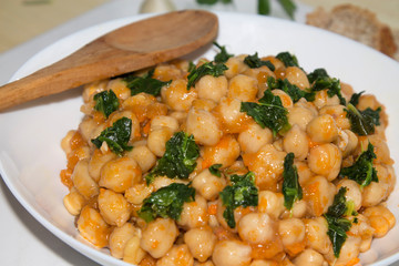bowl of cooked chickpeas with spinach closeup view