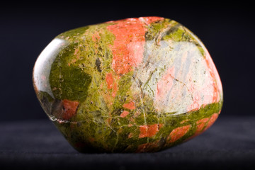 Macro photography of an unakite stone on a black background