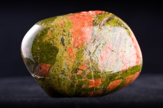 Macro photography of an unakite stone on a black background