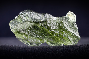 Macro photography of a moldavite stone on a black background