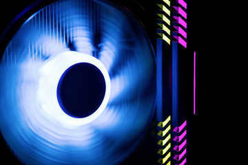 Inside a high performance computer. Powerful computer cooler in motion with blue backlight.  LED Light, CPU Cooler. RAM is highlighted in yellow and purple