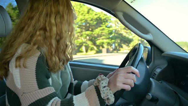 Teen girl leaning to backup car for driver education