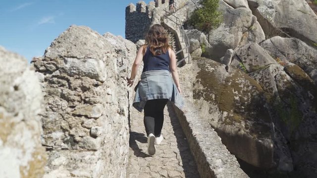 Tracking shot of a woman walking inside of Moorish Castle,  Sintra, Portugal.