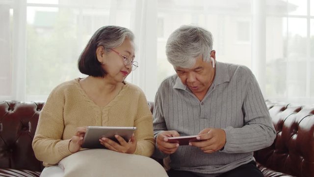 Elderly man wearing wireless earphone while playing game - Powered by Adobe