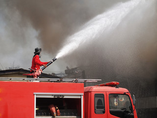 Obraz premium Fireman are spraying water to put out fire.