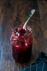 Cranberry Jam in Jar with Spoon / Cranberries Marmalade served with Bread Slices.