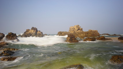 The splashing sea water in the red rock Karang Beureum beach, anten Province