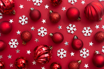 Christmas red background with red baubles, glitter and snowflakes with copy space. Winter christmas frame border.
