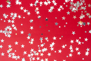 Obraz na płótnie Canvas Red background with silver glitter selective focus. Christmas texture mockup.