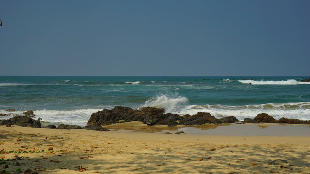 The splashing sea water in the red rock Karang Beureum beach, anten Province