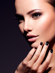 Face of a beautiful girl with fashion makeup and black nails