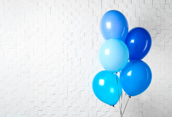 Bunch of blue balloons near white wall, space for text. Greeting card