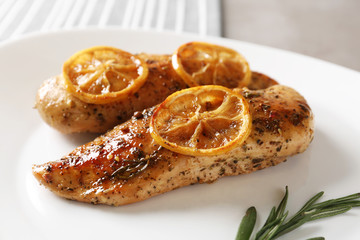 Delicious lemon chicken served on table, closeup