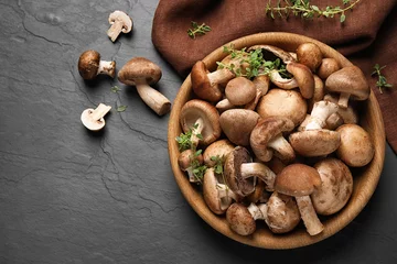 Fotobehang Different fresh wild mushrooms in bowl on black background, flat lay © New Africa