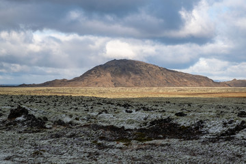 View over the moss and first snow covered lava field K&oacute;ngsfellshraun in the nature reserve Reykjanesf&oacute;lkvangur near Hafnarfj&ouml;r&eth;ur / Hafnarfj&ouml;rdur with the mountain Helgafell.