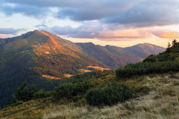 Mountain landscape with beautiful sunset, cloudy sky and orange colorful horizon. Happy fall. Touristic place Carpathian, Ukraine Europe.