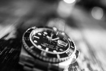 Close-up, shallow focus view of a well-known, Swiss manufactured mechanical diving watch showing...