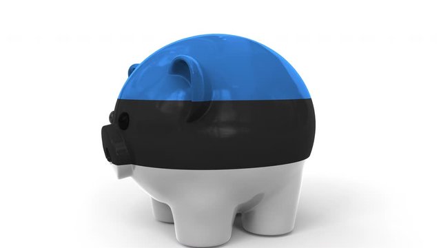 Coins fall into piggy bank painted with flag of Estonia. National banking system or savings related conceptual 3D animation