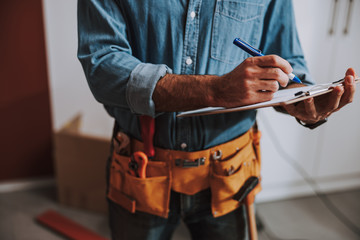 Construction worker writing on clipboard stock photo - 298443905