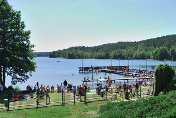 Obraz premium Crowded lake beach on a sunny summer weekend day