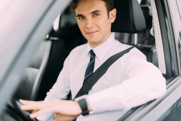 Smiling young businessman is driving stock photo