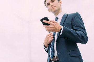 Young man in office suit with smartphone indoors stock photo