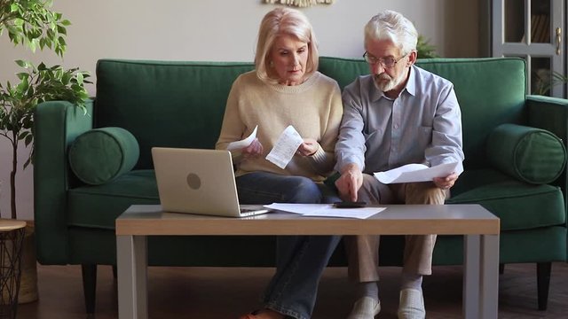 Elderly couple managing family budget checking expenses feels anxious