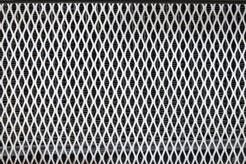 Silver diamond-shaped surface of radiator  from a vintage car  as a background. Metallic diamond-shaped mesh of grill of retro luxury rarity car pattern
