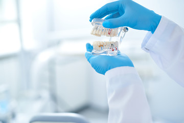 Dentist looking closely at the false teeth