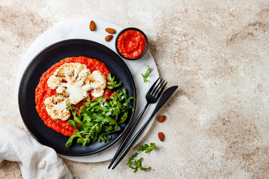 Roasted Cauliflower Steak With Red Pepper Romesco Sauce And Arugula Salad