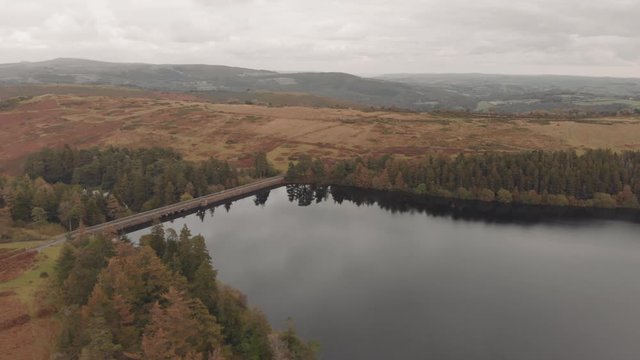 Aerial drone shot of reservoir, evergreen trees & autumn colors, Venford, Dartmoor National Park