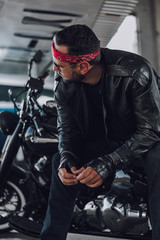Fototapeta na wymiar Caucasian biker looking at somebody in garage