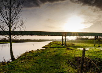 : Expansive view of a quarry conveyor system seen straddling over a rural location, caring...