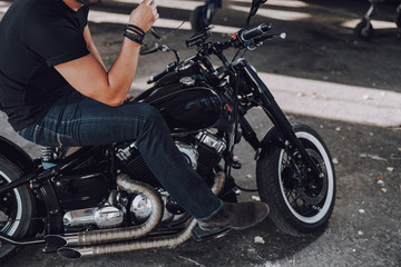 Fototapeta na wymiar Male biker is sitting on his black motorcycle