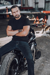 Fototapeta na wymiar Attractive Caucasian guy posing for camera in garage