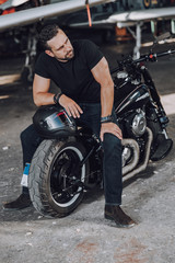 Naklejka na ściany i meble Handsome Caucasian guy sitting on new modern motorbike