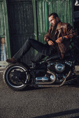 Naklejka premium Handsome biker is posing for camera outdoors