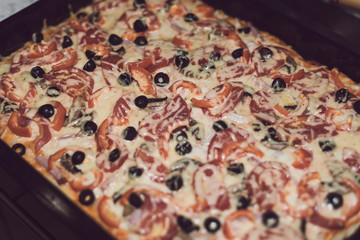 Delicious pizza with cheese and olives. Toned style photo. Pizza texture.