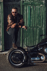 Obraz na płótnie Canvas Handsome biker is posing for camera outdoors