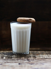 glass of milk cookies with chocolate chips on the background of wooden boards