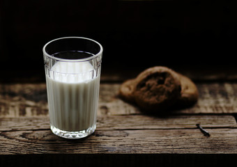glass of milk cookies with chocolate chips on the background of wooden boards