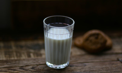 glass of milk cookies with chocolate chips on the background of wooden boards
