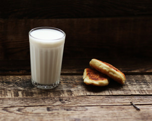 glass of milk cookies with chocolate chips on the background of wooden boards