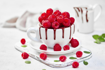 Raspberry mug cake in a white ceramic mug on white background