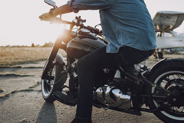 Naklejka premium Caucasian guy keeping hands on steering wheel of his motorcycle