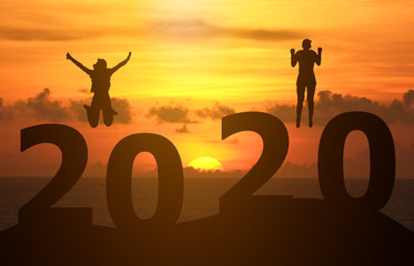 Concept Happy new year 2020 Silhouette image of happy man jump up to sunrise beautiful sky.