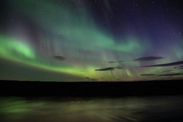 Northern lights with reflection in river, North Iceland