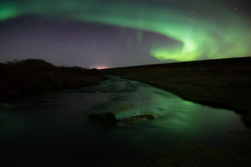 Northern lights with reflection in river, North Iceland
