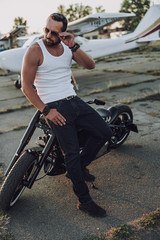 Obraz premium Bearded biker in modern sunglasses spending time oudoors